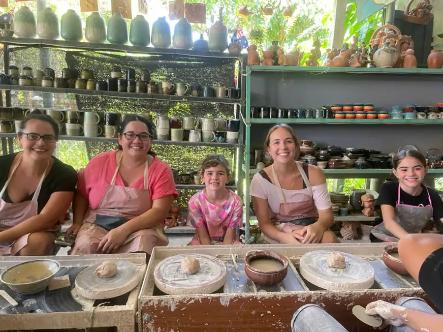 Whole family joining together in a cozy souvenir pottery shaping activity on a rainy day
