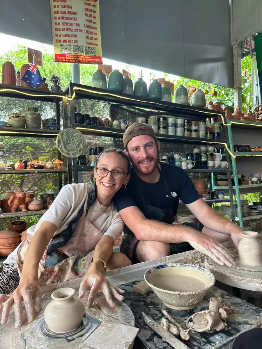 International tourists excitedly experiencing hand-shaping pottery at the Thanh Hu workshop