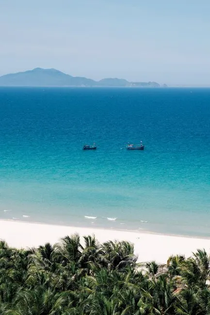 Breathtaking view of Cam Ranh's turquoise waters, sandy beach, and distant islands, perfect for a tropical getaway.