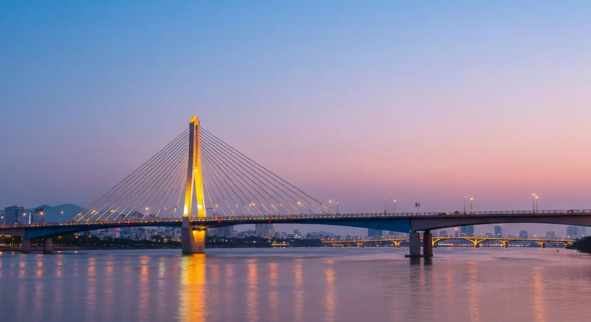 Nguyen Tri Phuong Bridge Da Nang viewed from the Han River bank with night lights and Dragon Bridge in the distance, exploring Da Nang's beautiful bridges