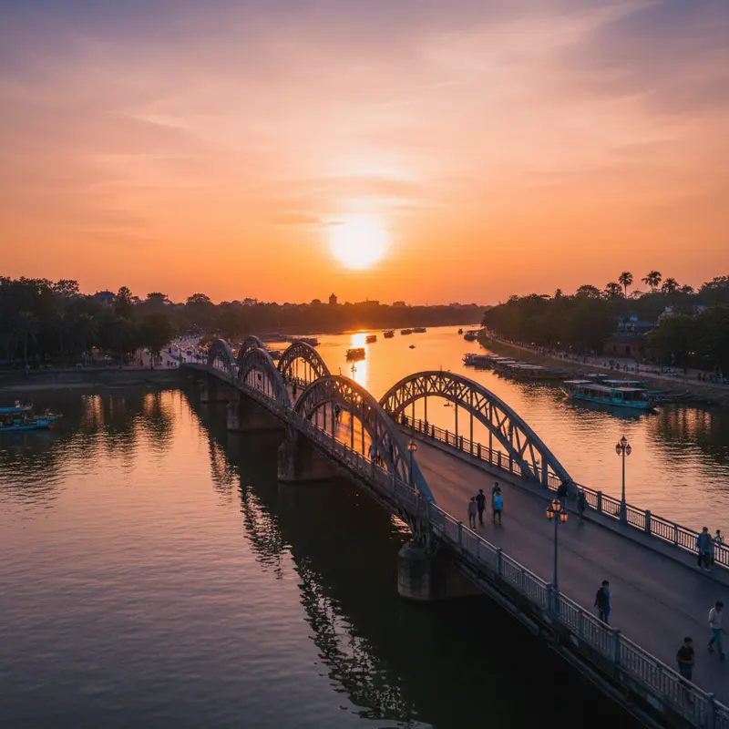 Trường Tiền Bridge in Hue at sunset with golden sunlight reflecting on the Perfume River, silhouettes of people walking on the bridge creating a romantic scene characteristic of the ancient capital – an unmissable tourist destination in Hue